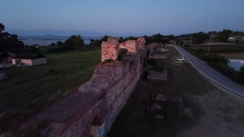 Drone aerial view flying backwards revealing ancient Nicopolis walls and rural Stock Footage 345168251