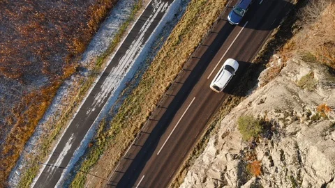 Drone aerial view flying down toward a country road asphalt with cars driving Stock Footage 104537511