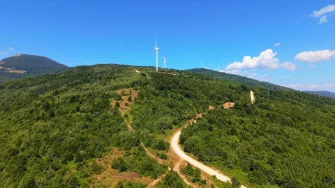 Drone Aerial View Flying Towards Wind Turbines on Mountain Ridge with Dirt Road  Stock-Footage 343675934