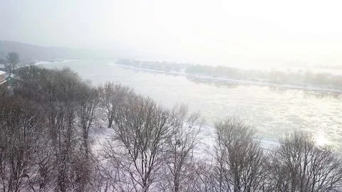 Drone aerial view flying in winter over park in front of the river Stock Footage