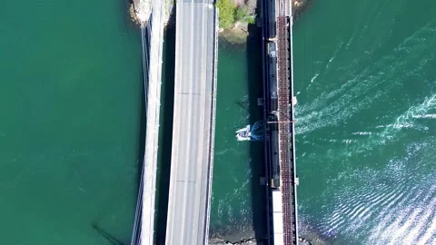 Drone aerial view of a freight train crossing railway tracks as cars travel Vídeos de archivo 348072397