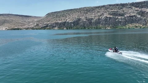 Drone Aerial View of Jet Ski Rider Speeding Across the River, May, 11, 2023, Video stock 336453936