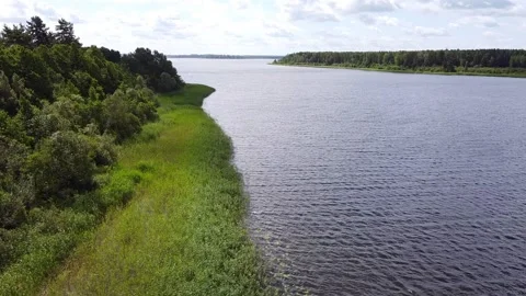 Drone aerial view of the lake and sun sets behind the clouds over the lake Stock Footage 247503653