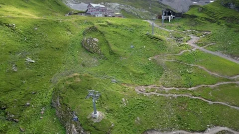 Drone aerial view of a large meadow and cable car structure to go up the Stock Footage 204786021