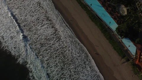 Drone aerial view to Ocean waves. Beach club swimming pool with relaxing people. Stock Footage 159844851