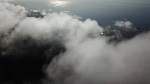 Drone aerial view of paraglider man flying over clouds and in Madeira island Stock Footage