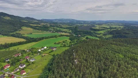 Drone aerial view of patchwork agricultural fields surrounding small village Stock Footage 346261551