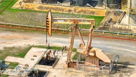 Drone aerial view of a pumpjack working at an oil extraction site. Video stock 330777142