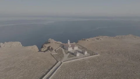 Drone aerial view of Punta Nati Lighthouse in Menorca, Balearic Islands - DLog Stock Footage 246499082