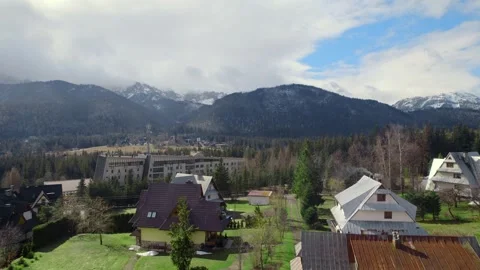 Drone aerial view of the rooftops of small village in mountains in sunny day Video stock 241810178