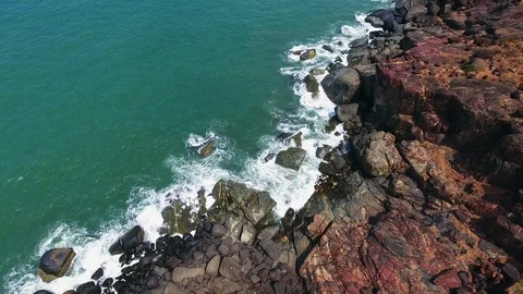 Drone aerial  view of sea waves reaching coastal black and red shore. 스톡 동영상 107697264