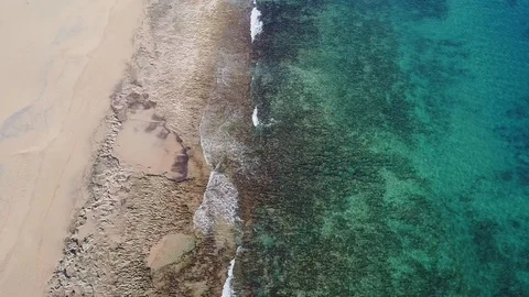 Drone aerial view of waves breaking on sand beach in Porto Santo island Stock Footage 116987806