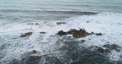 Drone aerial view of the waves breaking on the rocks off the coast on a clo.. 스톡 동영상 270363793