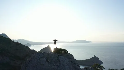 Drone aerial view of Young active woman standing on the summit with arms 動画素材 121659212