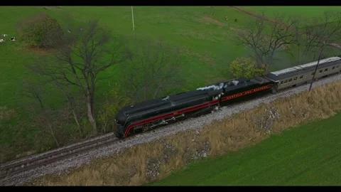 Drone Ahead of and Parallel View of a Steam Passenger Train Blowing Smoke a.. Stock Footage 230116716