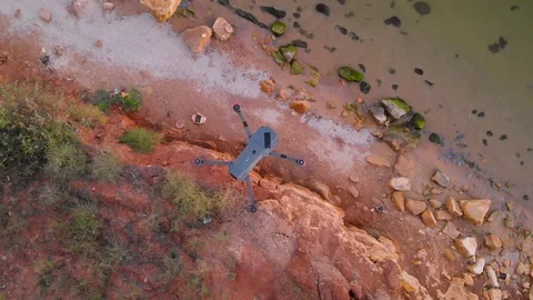 Drone in the air above the cliffs on the lake at sunset. Quadrocopter closeup. Stock Footage 97002575