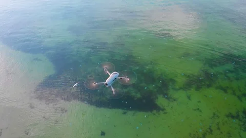 Drone in the air above the cliffs on the lake at sunset. Quadrocopter closeup. Stock Footage 98232155