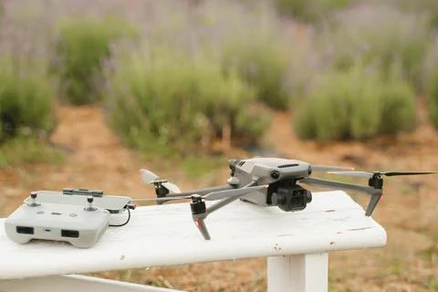 Drone and remote controller placed on a white bench in a field of lavender .. Stock Photos