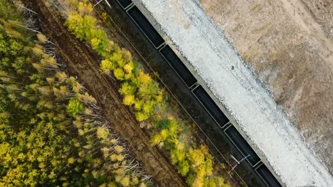 A drone at an angle of 90° flies over the railway tracks as a locomotive Stock Footage 235820343