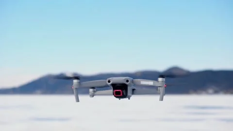 The drone appears in the frame slowly rising up, turns around and flies away. Stock Footage 173738463