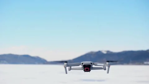 The drone appears in the frame slowly rising up, turns around and flies away. Stock Footage 191020219