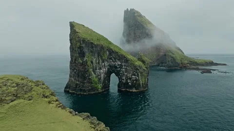 Drone Approach to a Large Grass-Covered Mountain Rock Island in Water Stock Footage 315098657