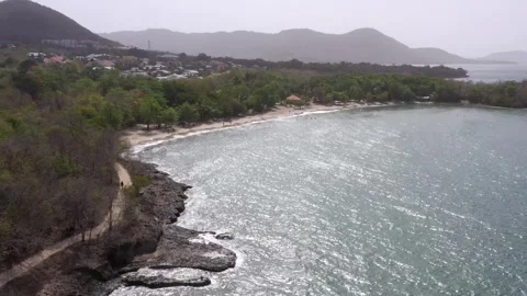 Drone Approach Over Misty Beach and Vegetation with Tourists – Martinique Stock Footage 317649013