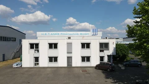 Drone approach through flags toward industrial company logo Stock Footage 331883209