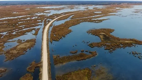 Drone approaches the road through the lake with shallows. North Shoal Lake Stock Footage