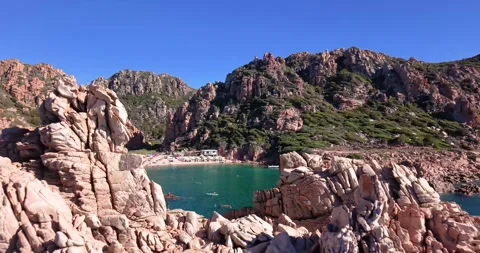 Drone Approaching Cala Li Cossi Beach Between Granite Cliffs Stock Footage 348390707