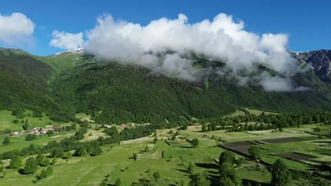 Drone Approaching Forested Mountain Slopes And Snowy Peaks 4K RAW Stock Footage 339724417