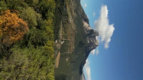 Drone approaching the mountain shot over the forest vertical video Stock Footage 228642085