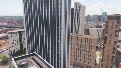 Drone approaching skyscraper with rope access window cleaners working on high Vidéo 334690417