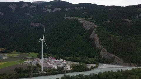 Drone Approaching Wind Turbine Above Industrial Gravel Processing Facility Stock Footage 336367529