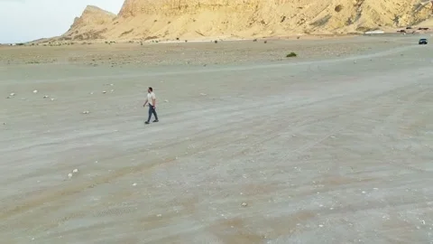 A drone around man walking along a deserted road Stock Footage 240096548