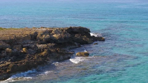 Drone around rockpool with turquoise waters and waves lapping Stock Footage 100264033