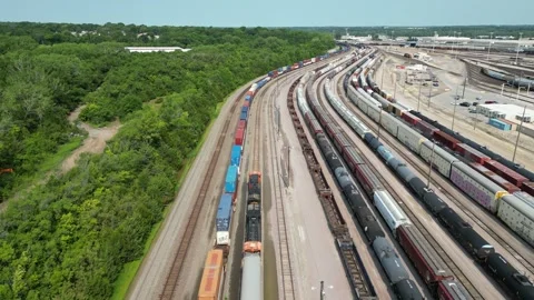 Drone ascending above moving train in busy Kansas City rail yard. Stock Footage 248482374