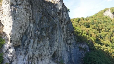 Drone Ascending Along Rock Face at Dariva Climbing Spot Revealing Houses Vídeo Stock 342716307