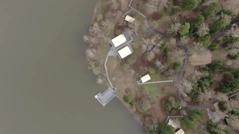 Drone ascending and rotating above riverside glamping Vidéo 329742459