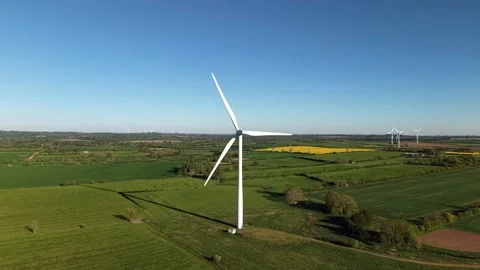 Drone ascending forward towards wind turbine over countryside fields Stock Footage 333935937