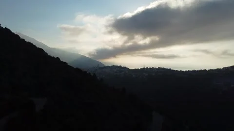 Drone Ascending Mountains With Sun Behind Clouds Video stock 331661086