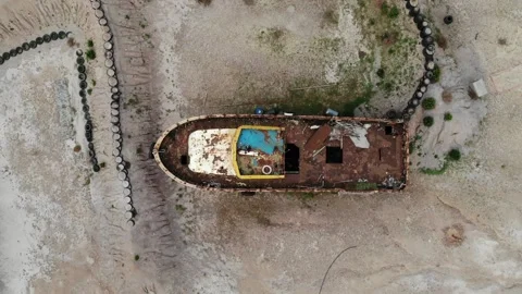 Drone Ascending Over Abandoned Boat in Patmos Revealing Surrounding Landscape Stock Footage 331661875