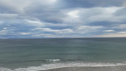 A drone ascending over a beach in Iceland with dramatic swirling clouds. Stock Footage 293088985