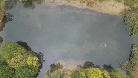 Drone ascending over a lake surrounded by trees. Stock Footage 255650591