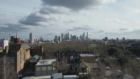 A drone ascending over a park capturing London’s financial district. Stock Footage 305437006