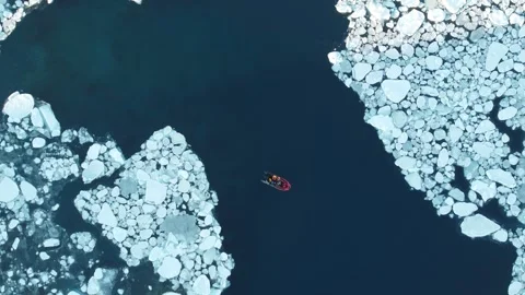 Drone ascending as scientists navigate a boat through Antarctic ice on a sunny d 스톡 동영상 327069046
