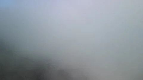 Drone Ascending Through Dense Mountain Fog into Clear Blue Sky Stock Footage 340324338
