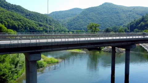 Drone Ascending Under Bridge as Vehicles Pass in Scenic Mountain Gorge Stock Footage 312901875