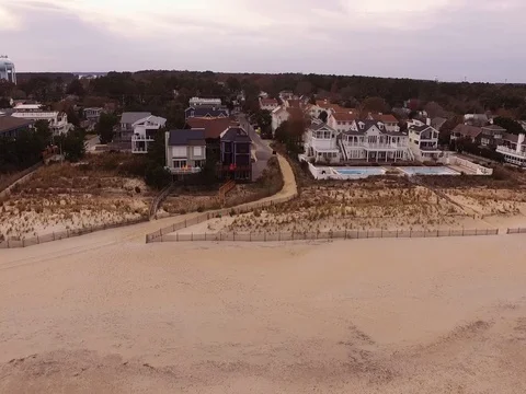 Drone ascends over beach town Stock Footage 82574693