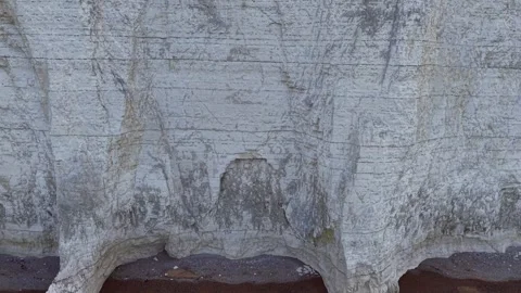 Drone ascends towering white cliff revealing peaceful grassland plateau Stock Footage 309764435